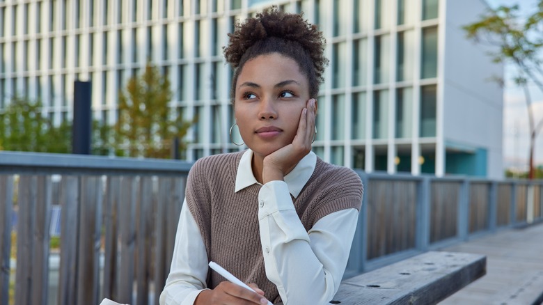 woman thinking and writing