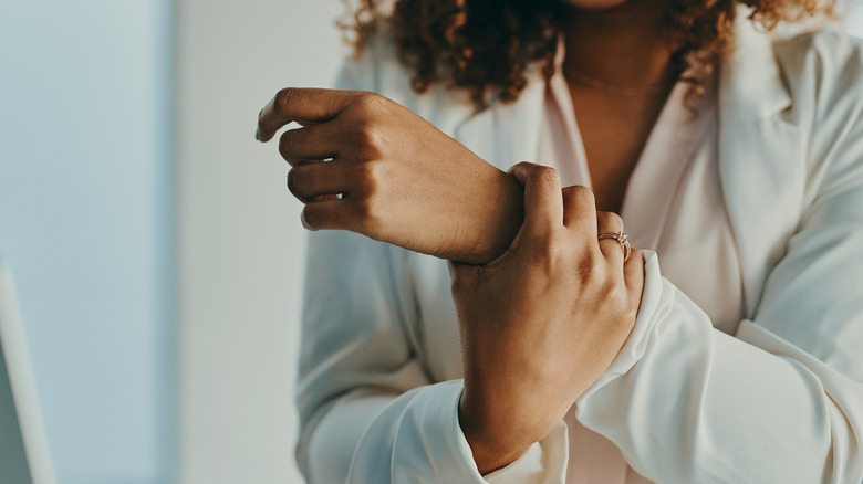 woman holds hand in pain