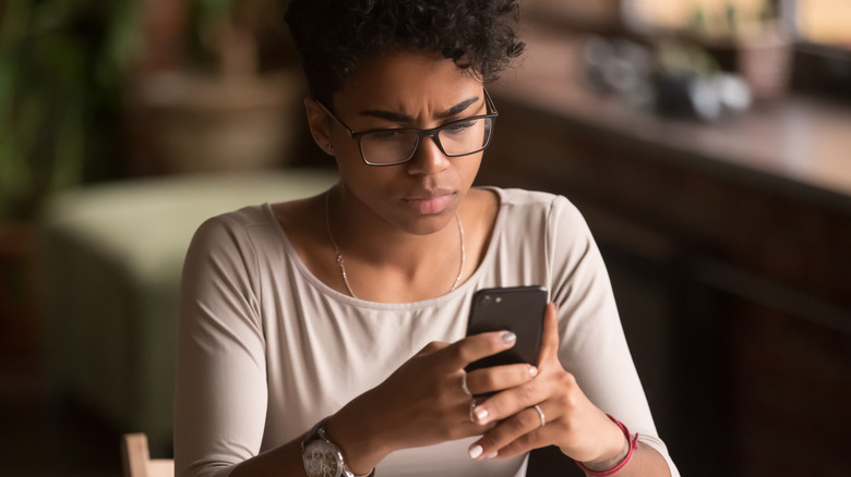 Black girl frowning at phone