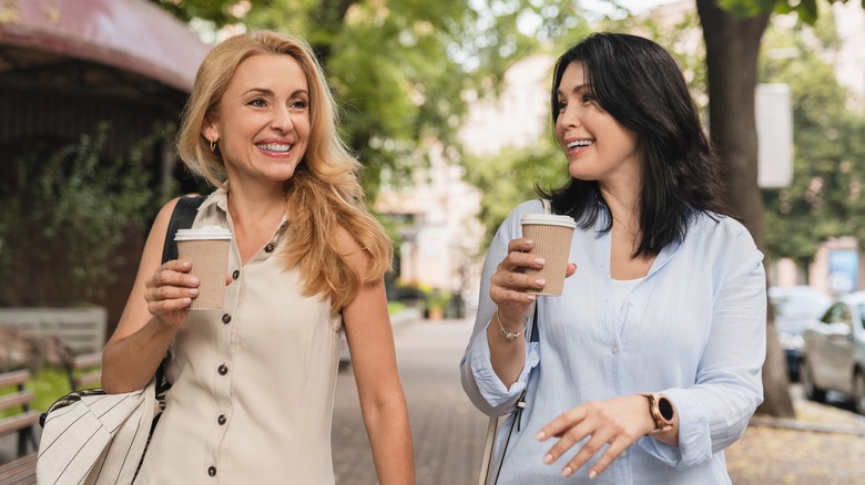 women walking with coffee cups