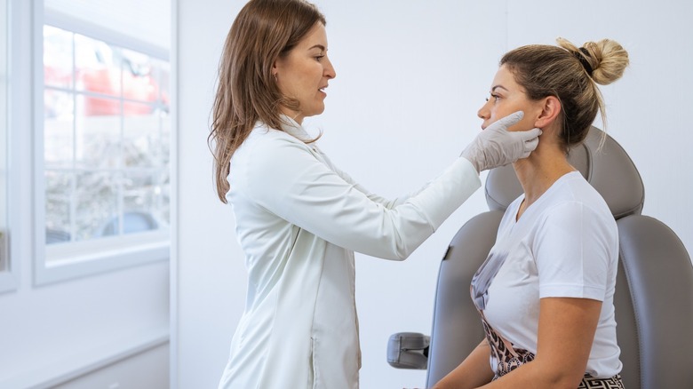 Dermatologist assessing patient's face