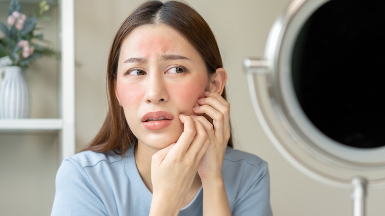 Woman scratching skin breakout 