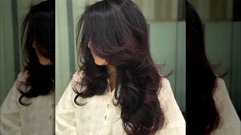 Woman with layered burgundy hair tone