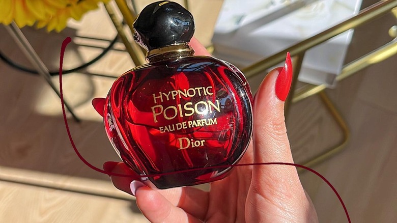 Holding Dior Hypnotic Poison bottle