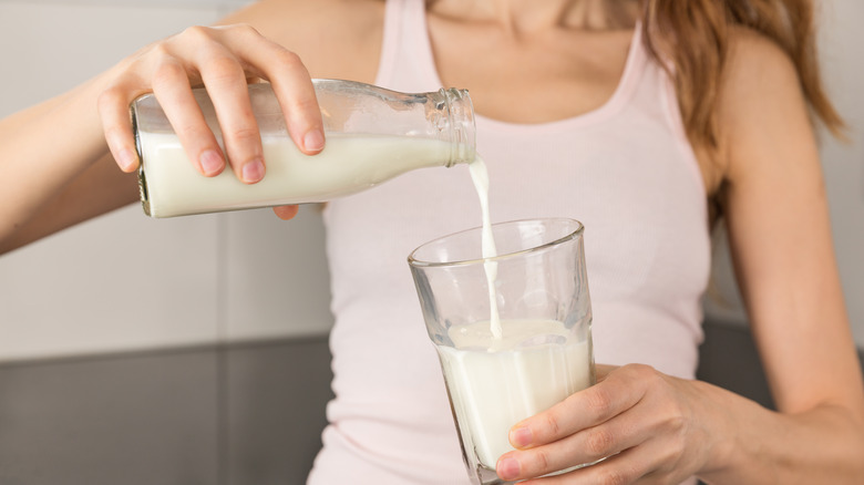 Woman pouring milk in glass