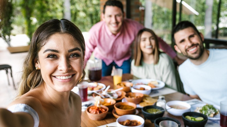 Four people smiling and sitting at table