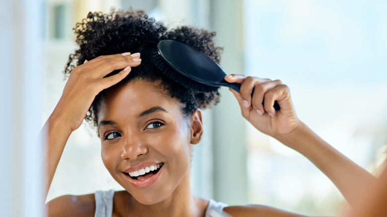 Woman with curly hair using brush