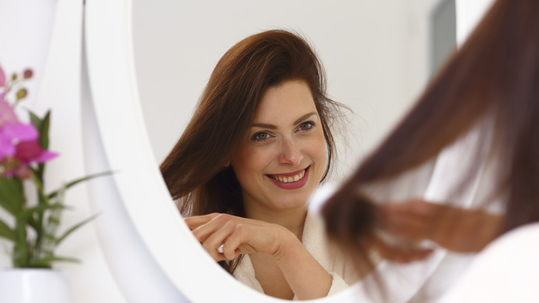 Happy woman brushing hair