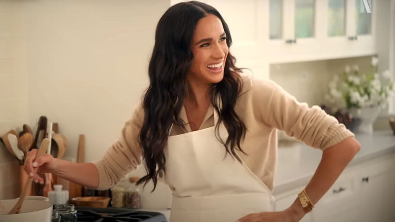 Meghan Markle cooking in a beige cardigan on 