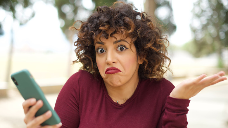 Model with short curly hair shrugging