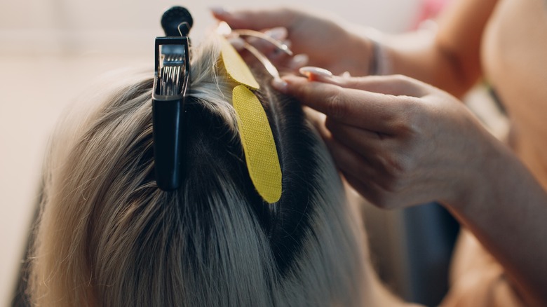 Stylist installing hair extensions