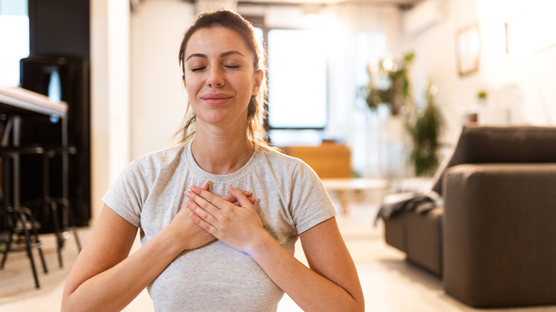 woman with hands on her chest