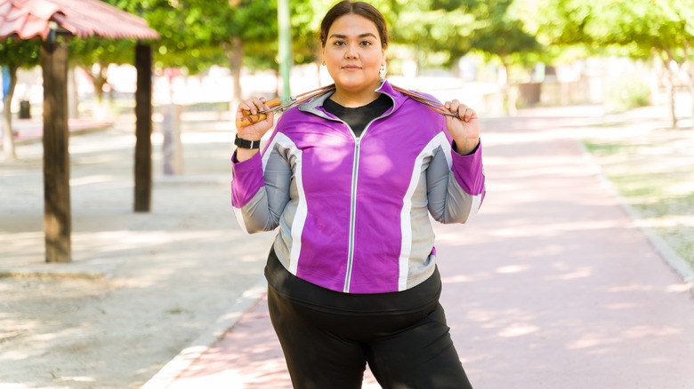 woman tracksuit holding jump rope