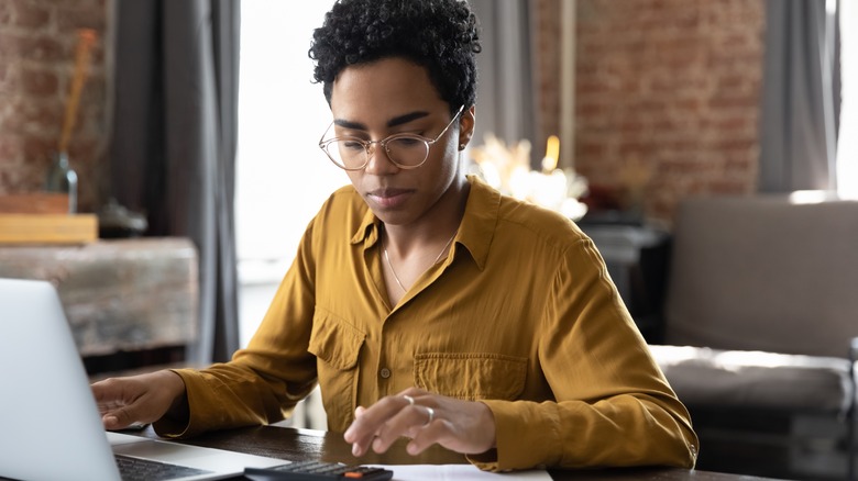 Woman using calculator at desk