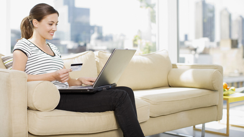 Woman shops online on sofa