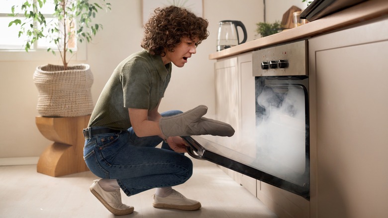 Woman burns meal in oven