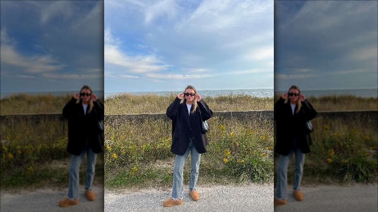 woman standing next to grass with oversized blazer and jeans