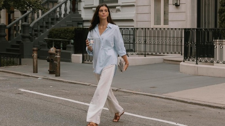 woman crossing street with oversized button up and loose pants