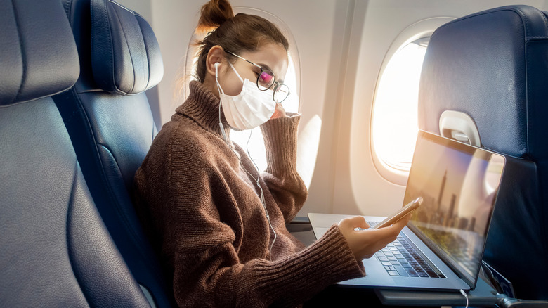 Woman wears mask on plane