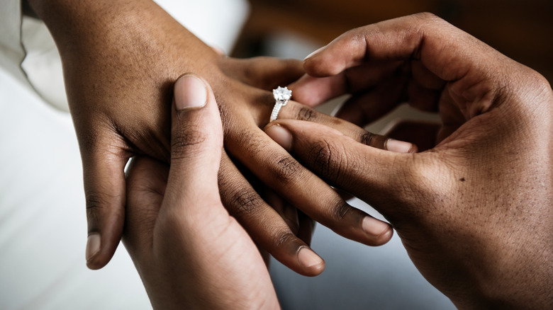 man proposes marriage to woman on sofa