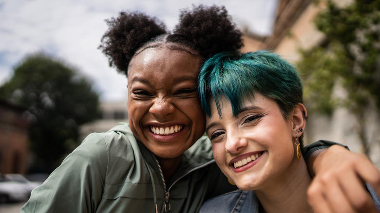 Women smiling arms around each other