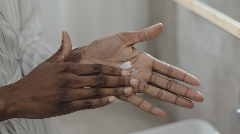 woman applying moisturizer to hands