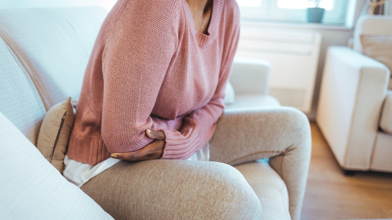 woman with period cramps holding stomach