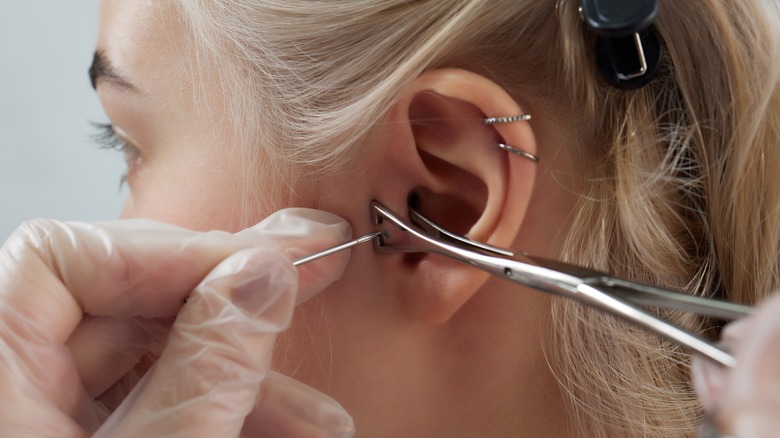 woman getting ear pierced