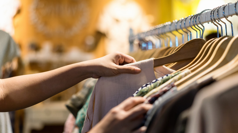 person looking through clothing rack 