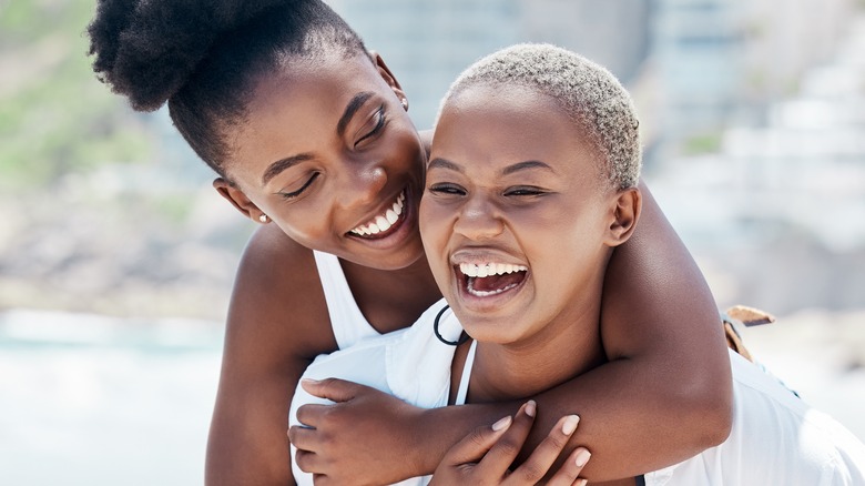 Two women laughing on beach