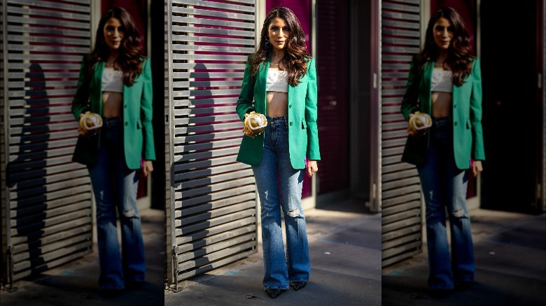 Woman wearing green blazer and jeans 