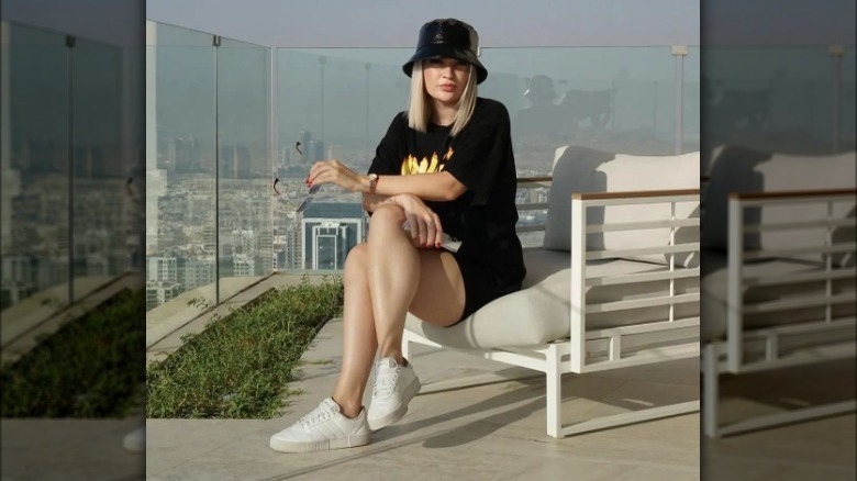 Woman models casual black outfit with hat