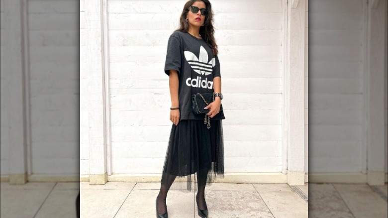 Woman models oversized tee shirt and formal skirt