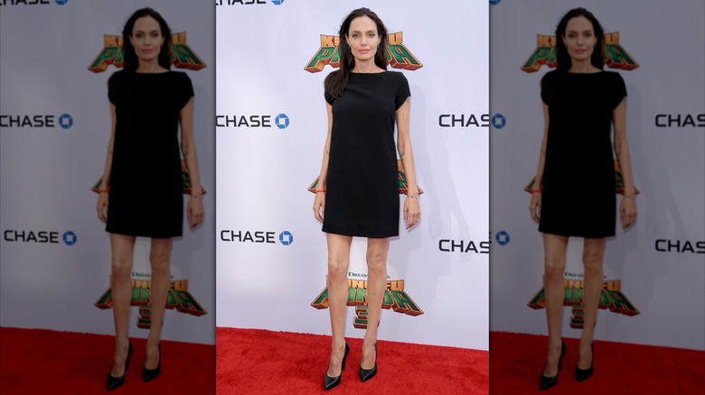 Angelina Jolie wearing a black mini dress on the red carpet.