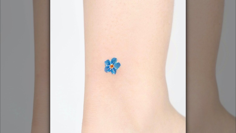 Small blue watercolor flower tattoo