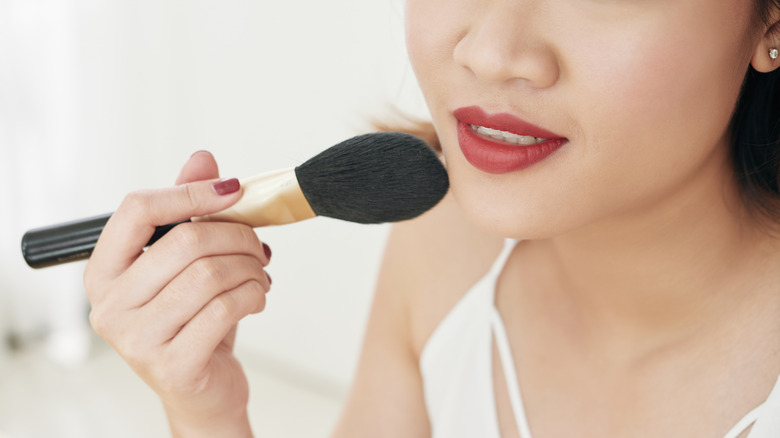 woman using brush on lips