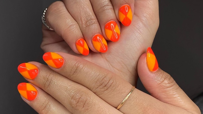 fingers with two-toned orange manicure
