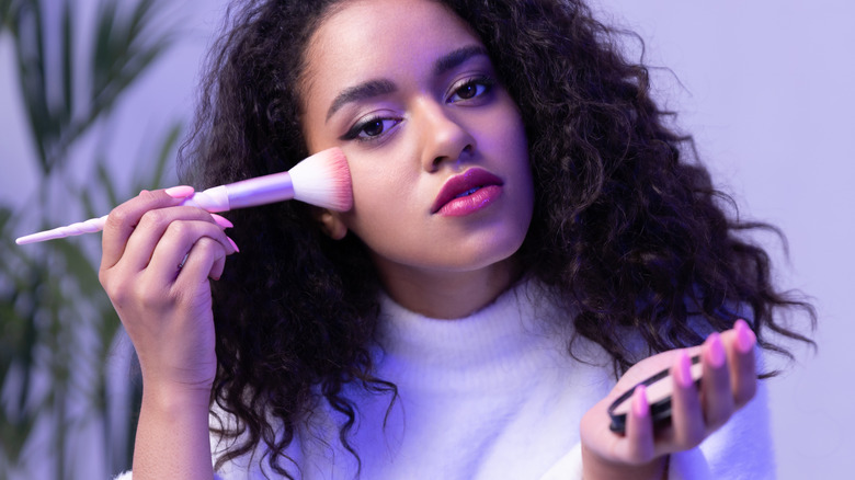 woman applying powder with brush