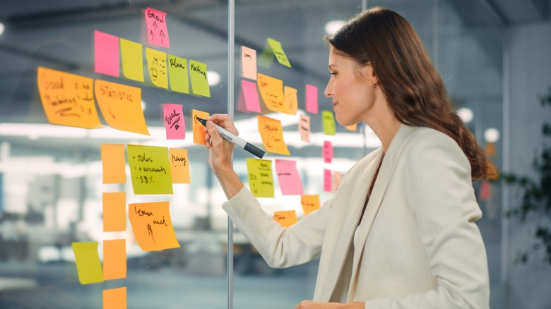 Woman writing on sticky notes