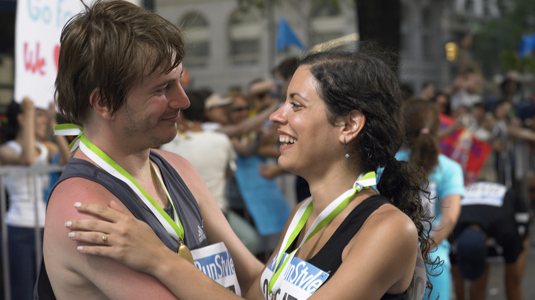smiling and hugging marathon runners 