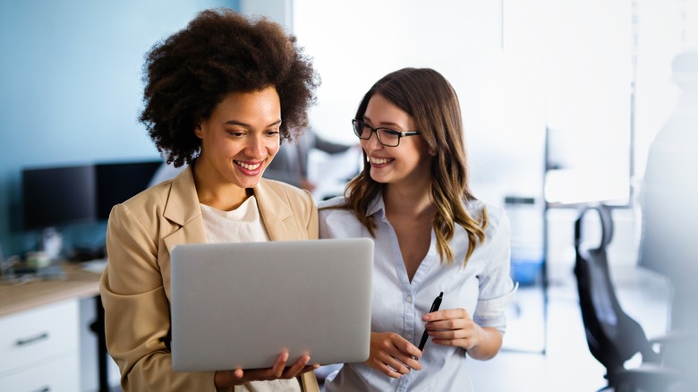 Coworkers looking at a laptop 