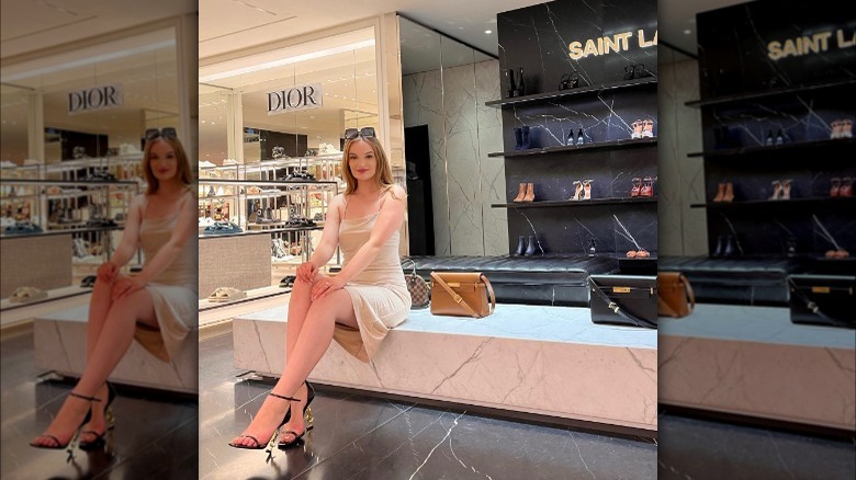 Girl in a mall wearing YSL logo heels.