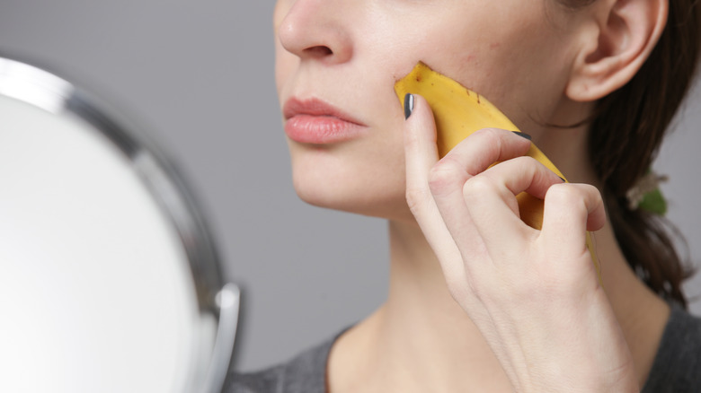 Woman using banana on skin