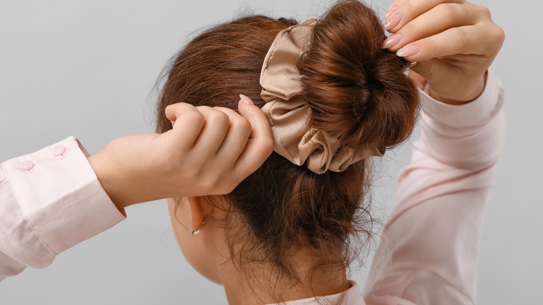 A woman wearing a silk scrunchie