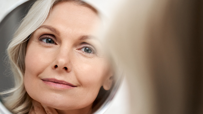 Woman looks at mirror reflection