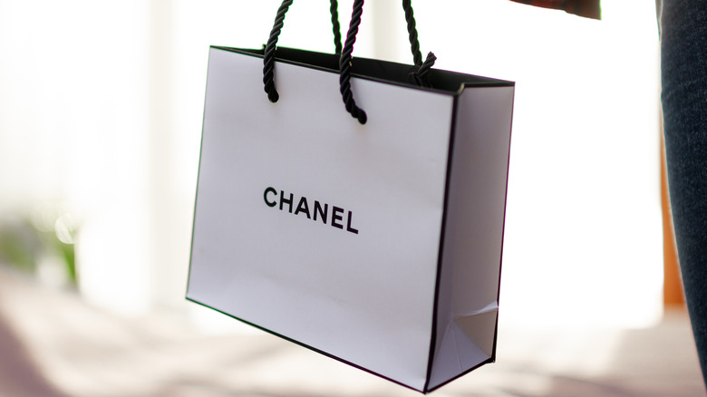 person carrying chanel retail bag