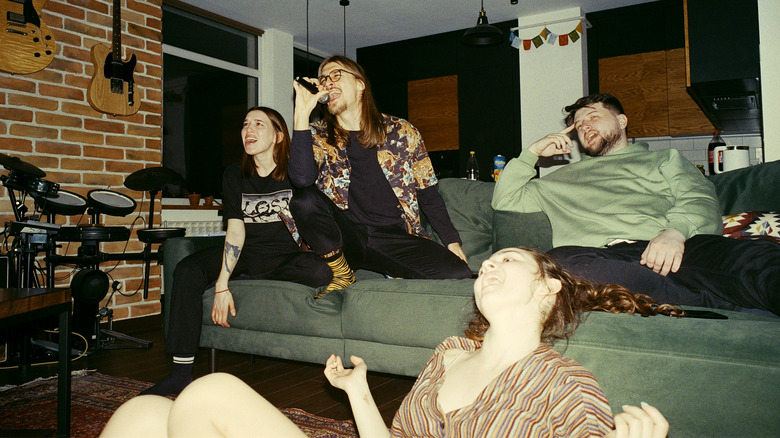 Friends singing karaoke in living room