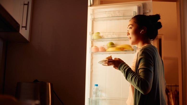 Woman looking at food in fridge