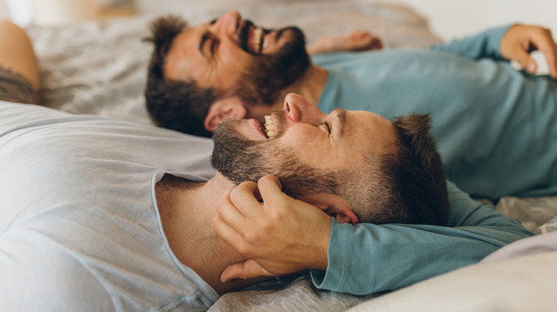 gay couple laughing in bed