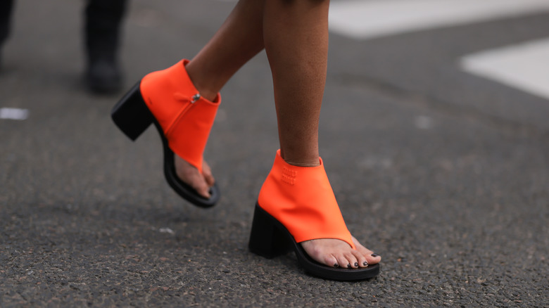 Person in neon orange thong boots